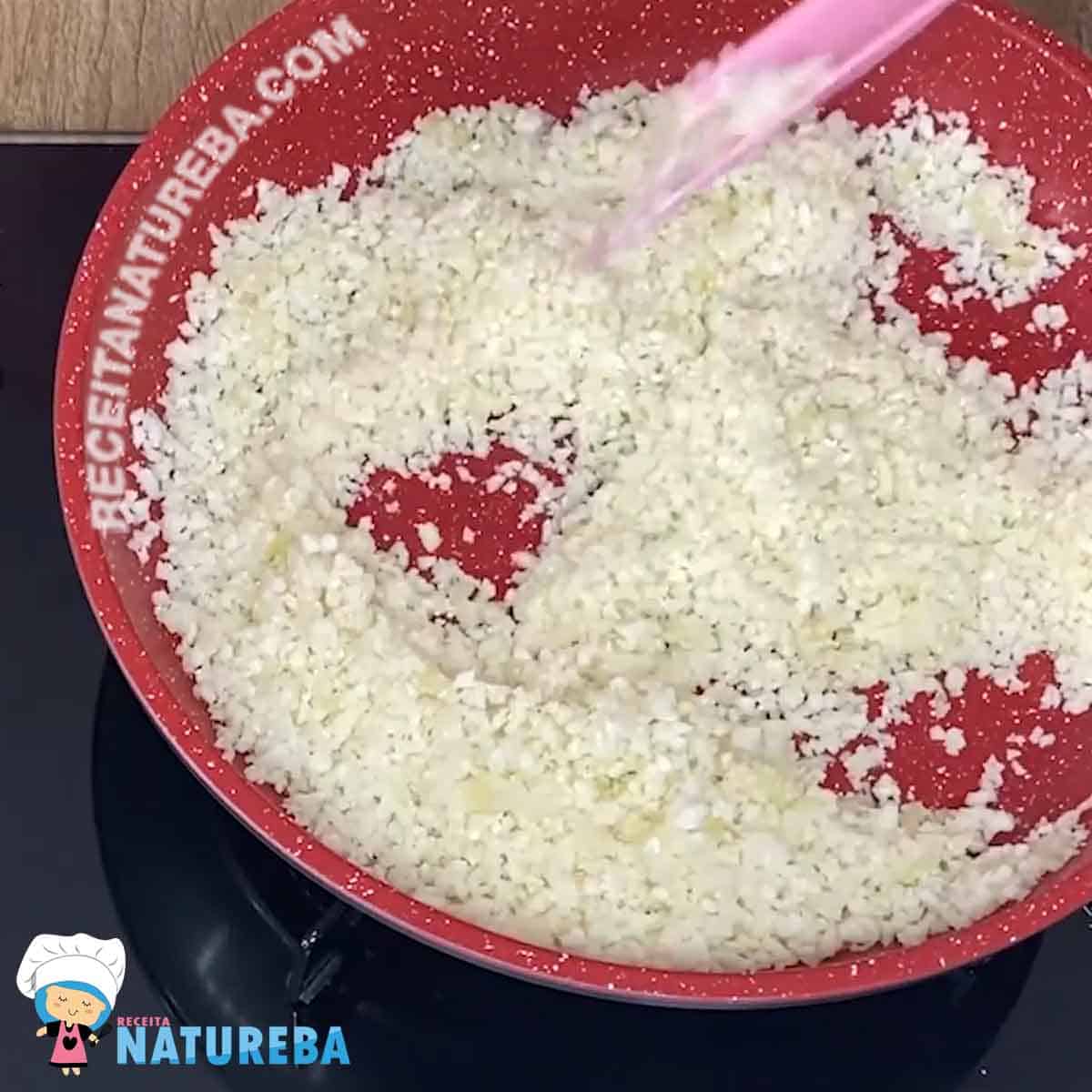 refogando o arroz de couve flor numa frigideira vermelha