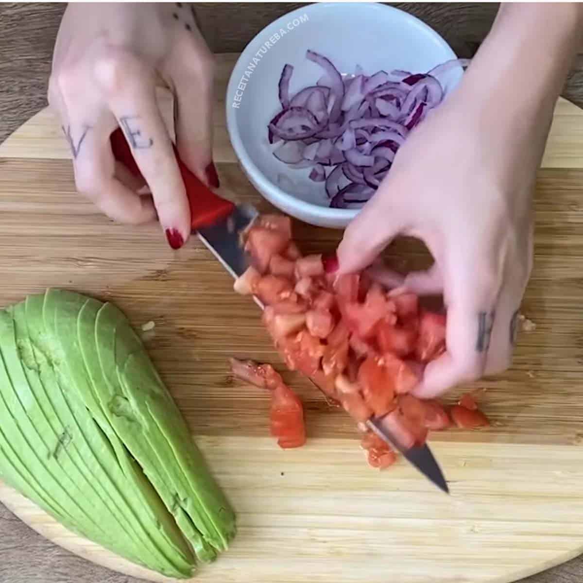 picando a cebola e o tomate para a salada de abacate