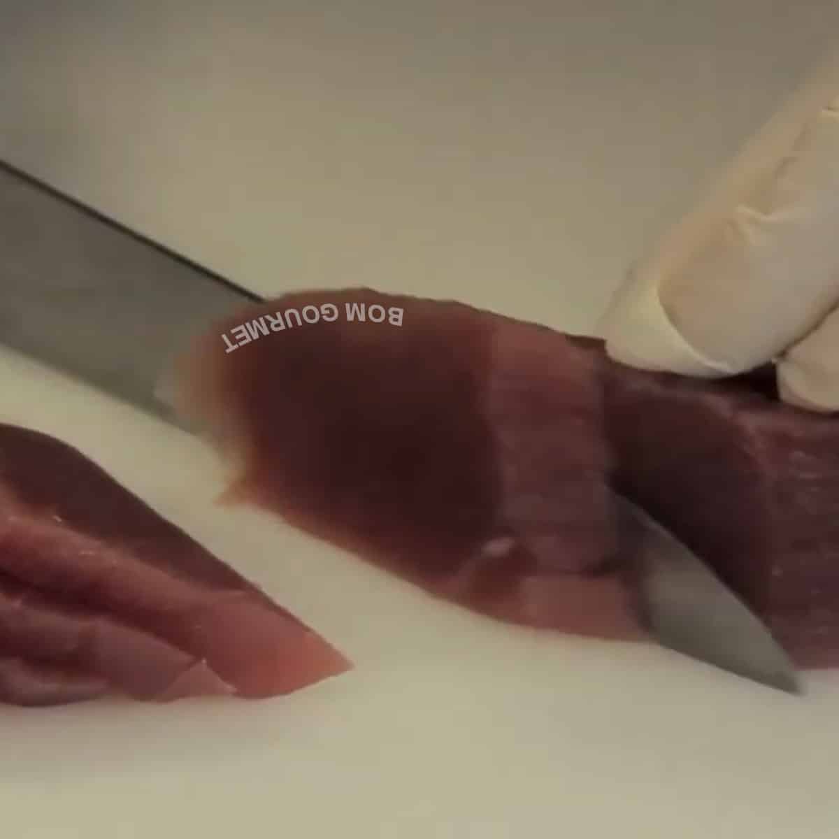 cortando sashimi de atum na diagonal