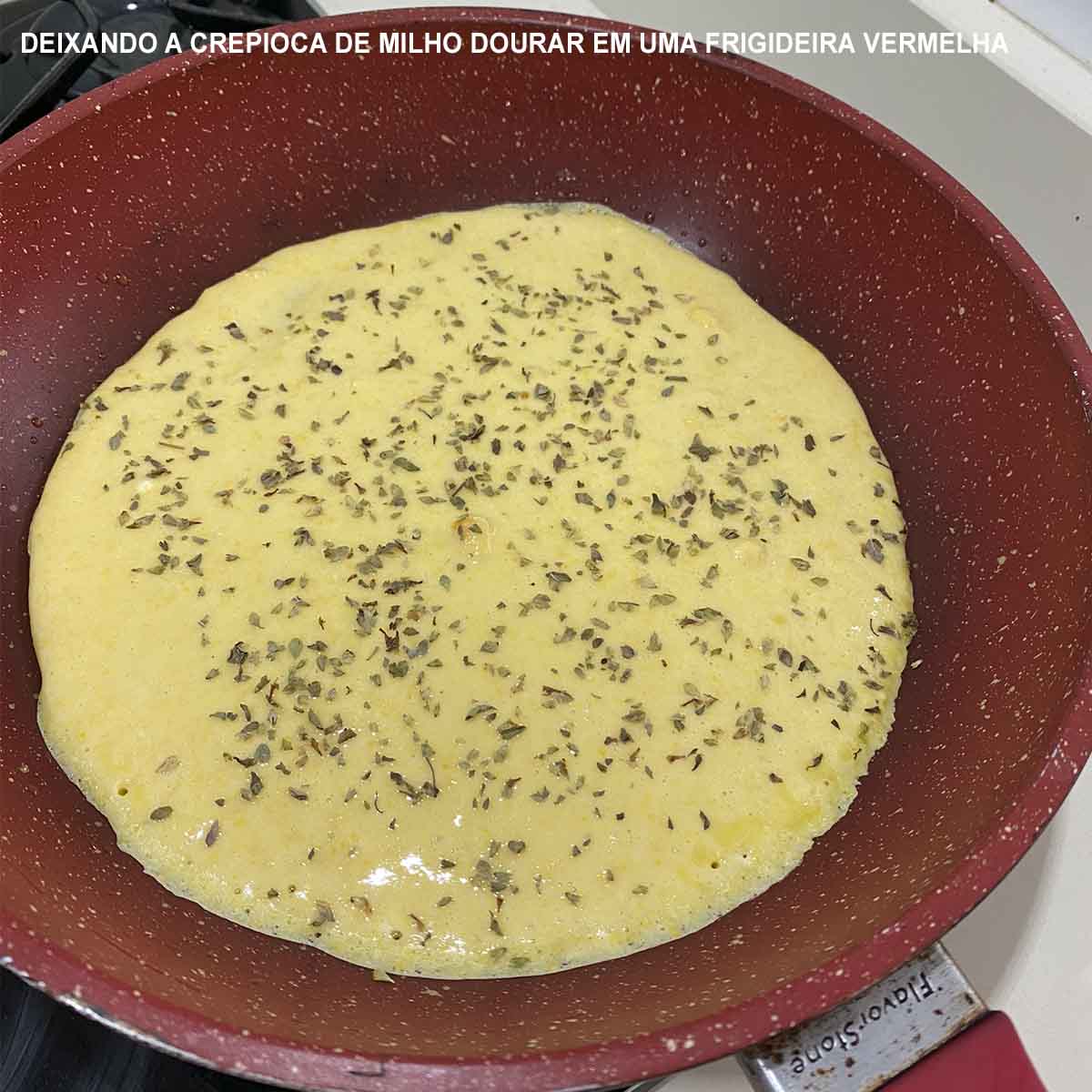 deixando a crepioca de milho dourar em uma frigideira vermelha