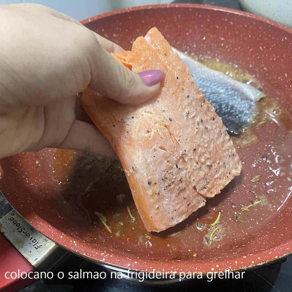 colocano o salmao na frigideira para grelhar